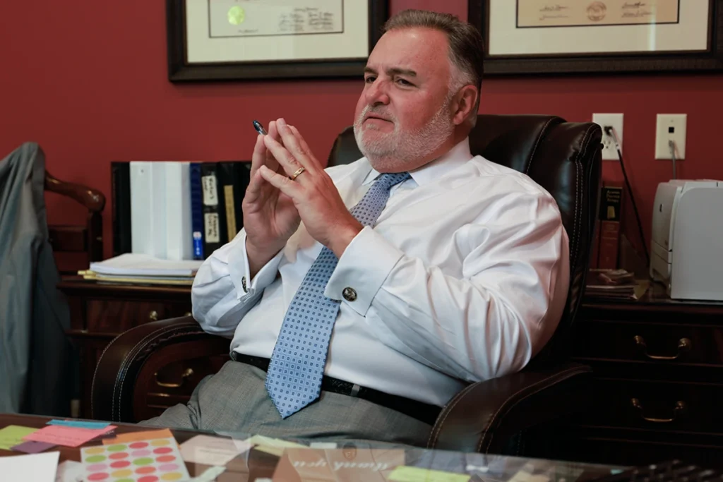 Attorney joel hamner explains a garbage truck accident exhibit to a client, showing route and collision data.