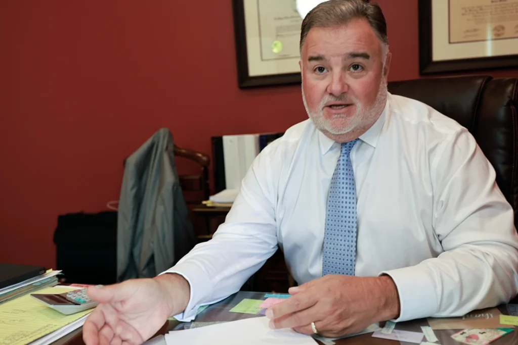 Attorney joel hamner explains a lumbar injury exhibit to a client, showing mri scans.