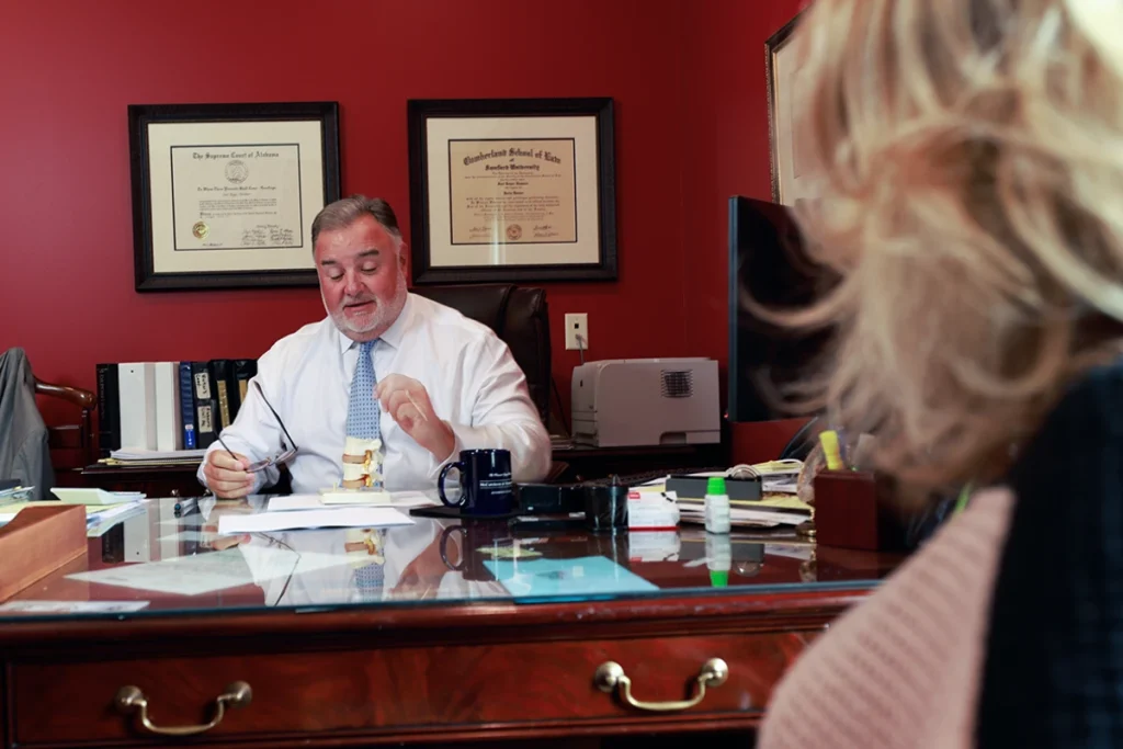 Attorney joel hamner explains a severe injury exhibit to a client, highlighting long term care needs.