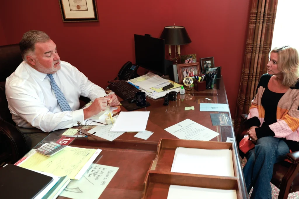 Attorney joel hamner explains a talcum powder injury exhibit to a client, featuring product testing data.