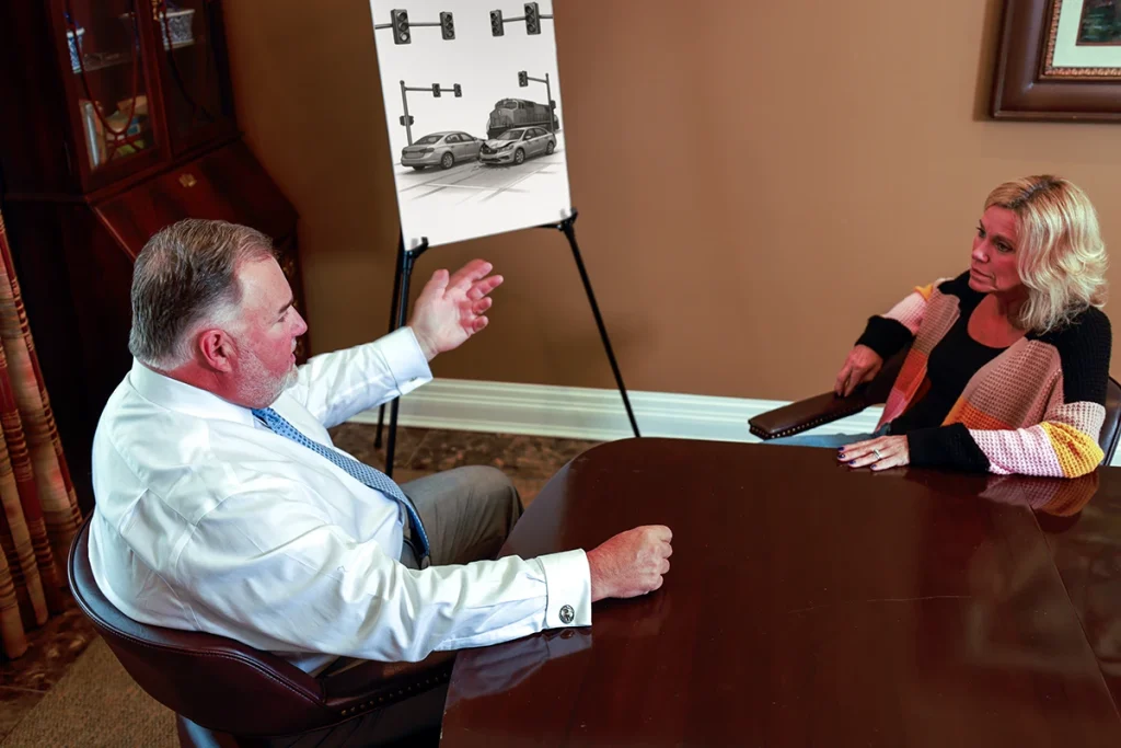 Attorney joel hamner meets with a client to discuss an intersection accident exhibit showing traffic signal timing.