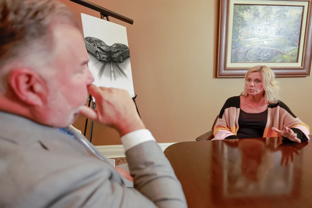 Attorney joel hamner presents a head on collision exhibit to a client, highlighting impact diagrams.