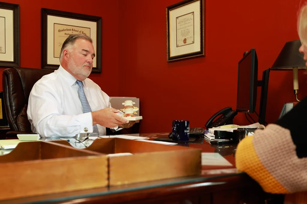 Attorney joel hamner reviews a usps accident exhibit with a client, focusing on mail truck crash evidence.