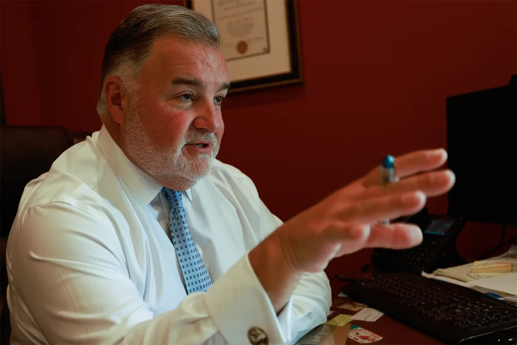 Attorney joel hamner reviews a burn injury exhibit with a client, noting fire investigation findings.