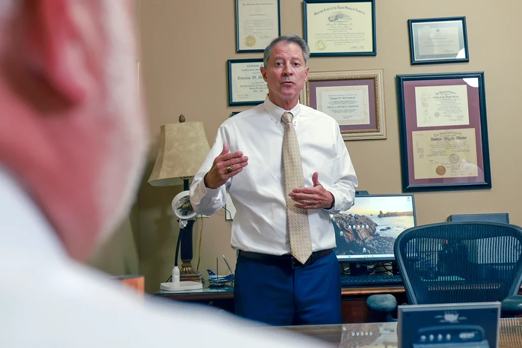 Attorneys joel hamner and tom mccutcheon talk with a client about a product liability injury claim.