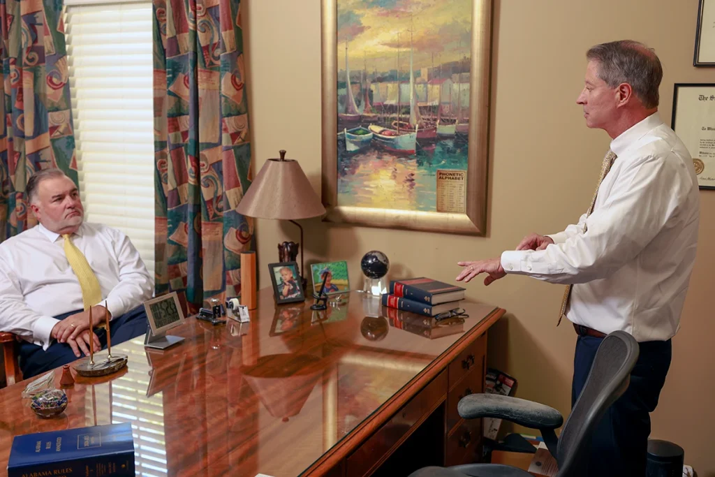 Attorneys joel hamner and tom mccutcheon talk with a client about other vehicle accident claims.