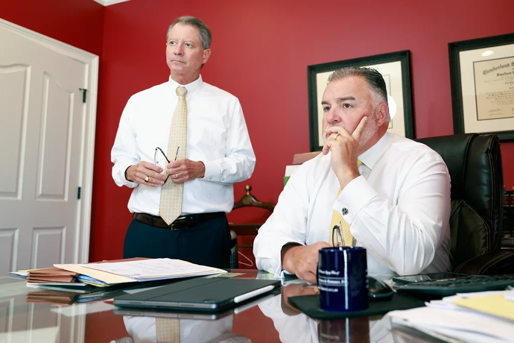 Attorneys tom mccutcheon and joel hamner consult with a client about a homeowner liability injury case.