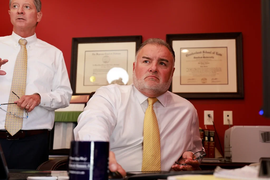 Attorneys tom mccutcheon and joel hamner discuss contamination reports with a client about a chemical exposure claim.