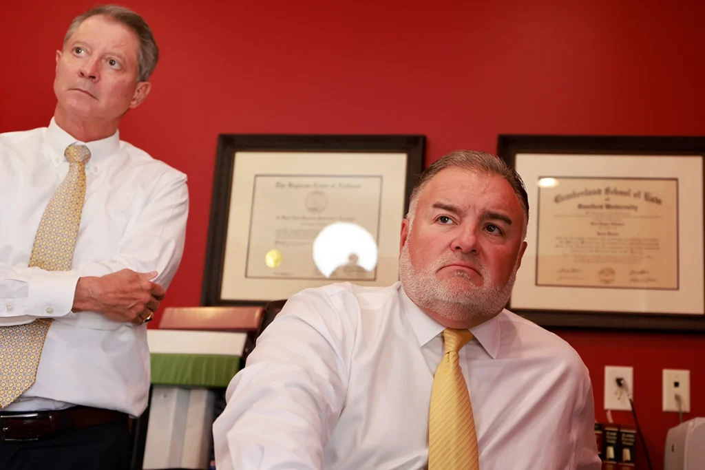 Attorneys tom mccutcheon and joel hamner review accident details with a client about a concussion and tbi claim.