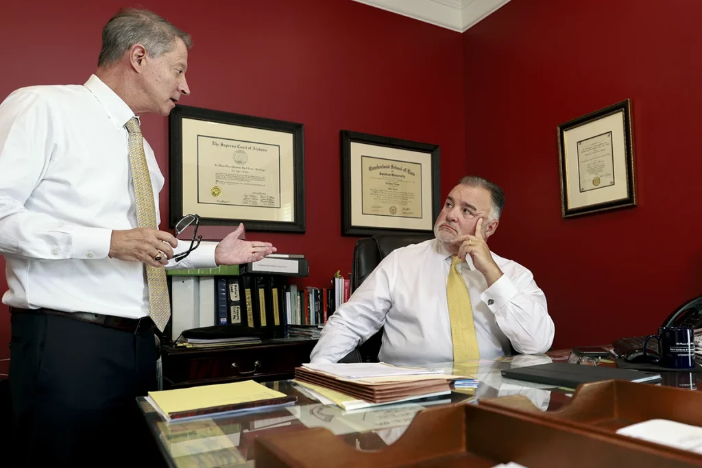 Attorneys tom mccutcheon and joel hamner review diagnostic scans with a client for a whiplash and neck injury case.