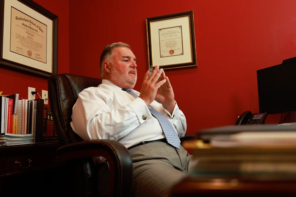 Lawyer joel hamner discusses a golf cart accident exhibit with a client, highlighting course safety issues.