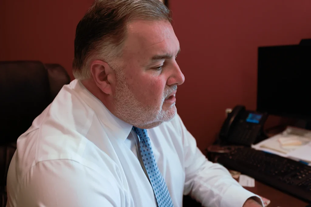 Lawyer joel hamner discusses a heavy machinery accident exhibit with a client, highlighting equipment failure analysis.