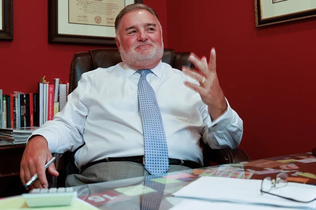 Lawyer joel hamner discusses a paralysis injury exhibit with a client, highlighting spinal cord data.