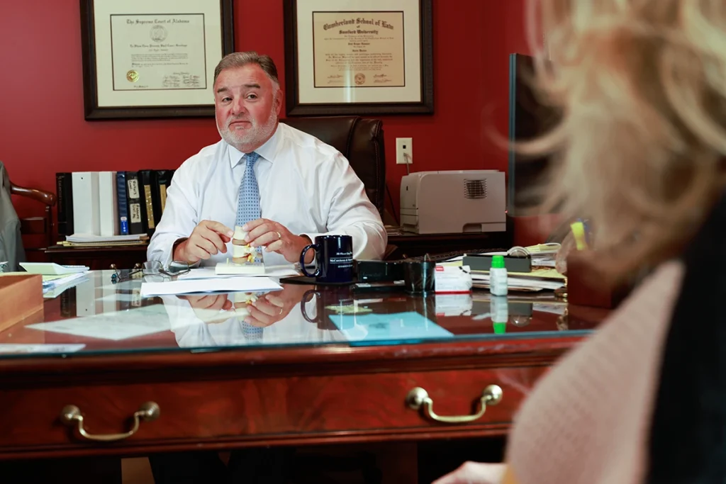 Lawyer joel hamner discusses an electrocution accident exhibit with a client, pointing out wiring hazards.