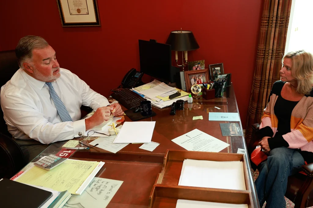 Lawyer joel hamner explains a defective medical device exhibit to a client, outlining testing reports.