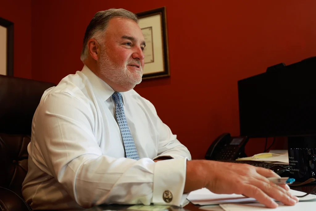 Lawyer joel hamner explains a multiple vehicle collision exhibit to a client, tracing chain reaction impacts.