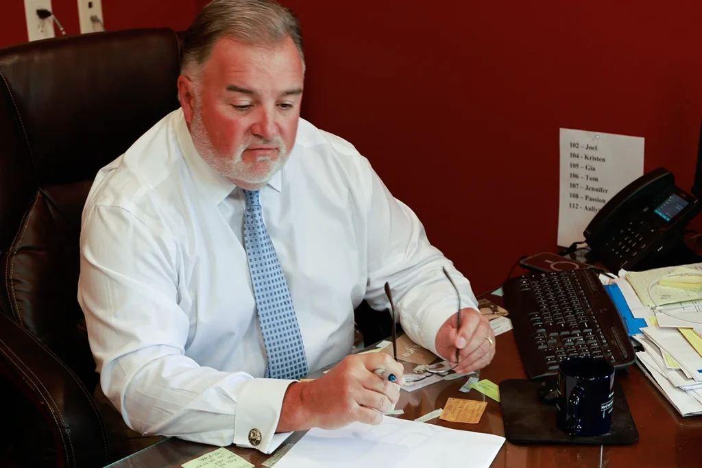 Lawyer joel hamner explains an intersection accident exhibit to a client, focusing on traffic signal timing.