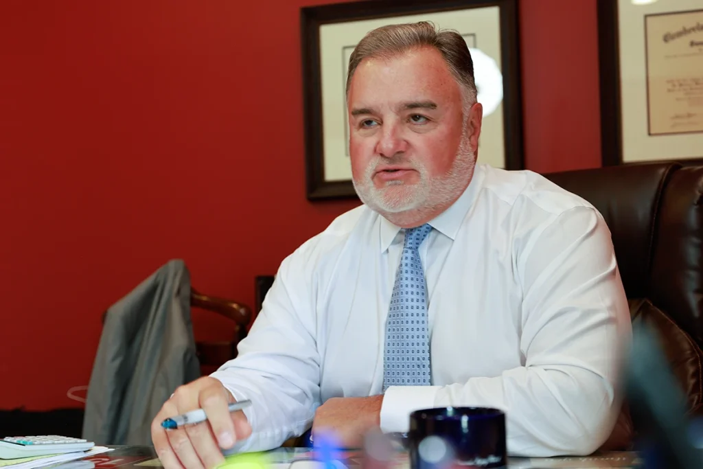 Lawyer joel hamner meets with a client to discuss a reckless driving exhibit showing speed evidence.