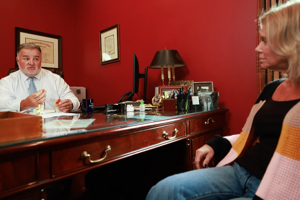 Lawyer joel hamner presents a freeway accident exhibit to a client, noting traffic flow diagrams.