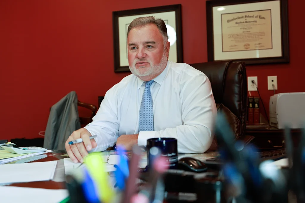 Lawyer joel hamner reviews a dirt bike accident exhibit with a client, noting trail conditions and crash details.
