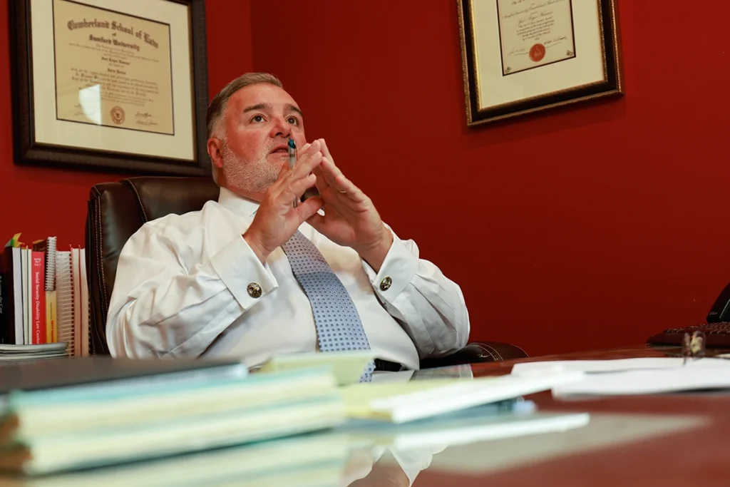 Lawyer joel hamner reviews a helicopter accident exhibit with a client, showing flight path graphics.