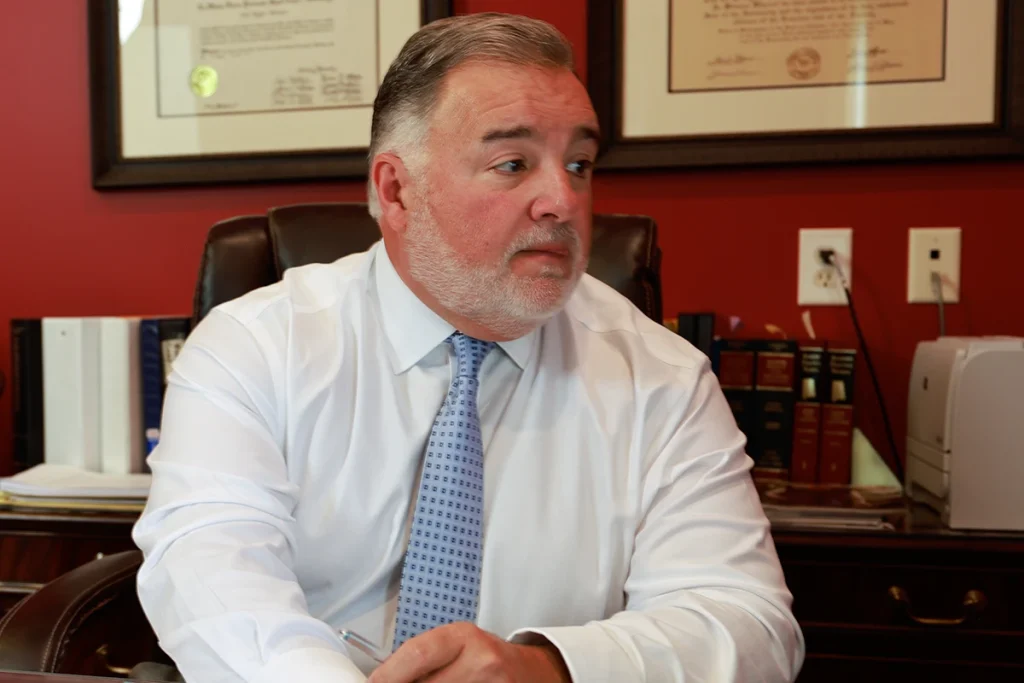 Lawyer joel hamner reviews a vacation rental liability exhibit with a client, highlighting unsafe rental conditions.