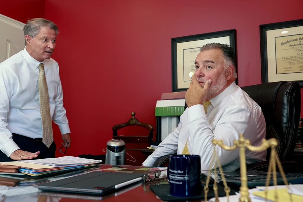 Tom mccutcheon and joel hamner consult with a client to discuss the merits of a wrongful death lawsuit.