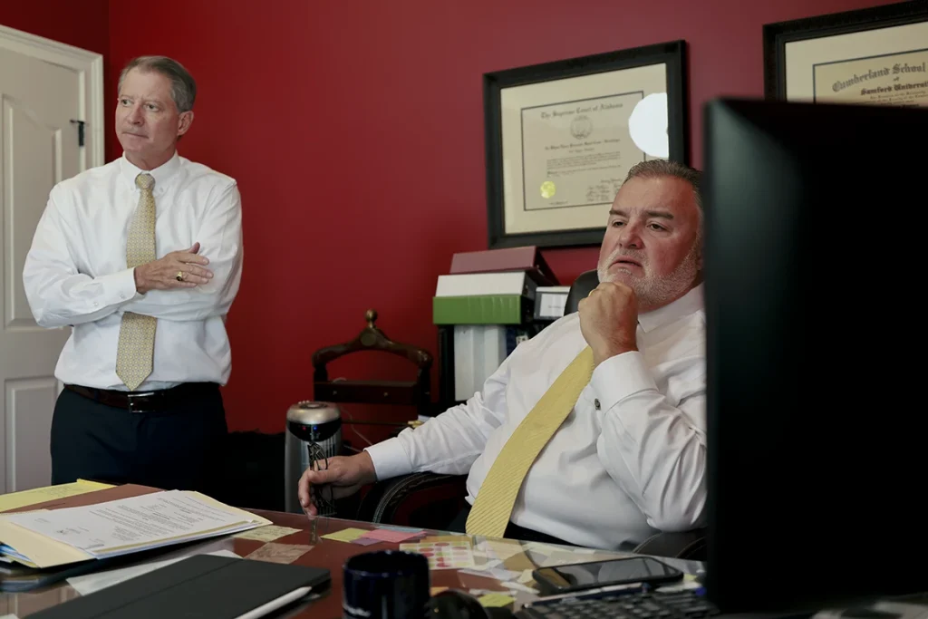 Tom mccutcheon and joel hamner discuss a slip and fall accident claim with a client during the consultation.
