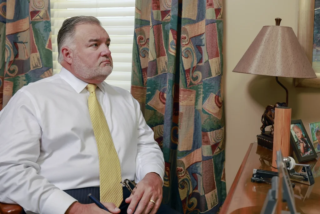 Tom mccutcheon and joel hamner meet with a client in tom’s office to review a dirt bike accident case.