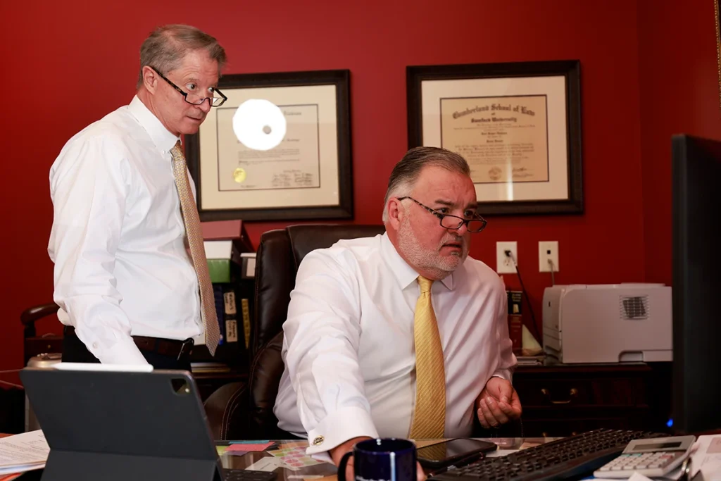 Tom mccutcheon and joel hamner meet with a client to discuss evidence in a brake failure accident case.