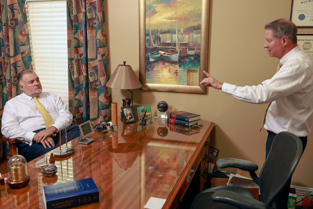 Tom mccutcheon and joel hamner meet with a client to review a passenger injury case.