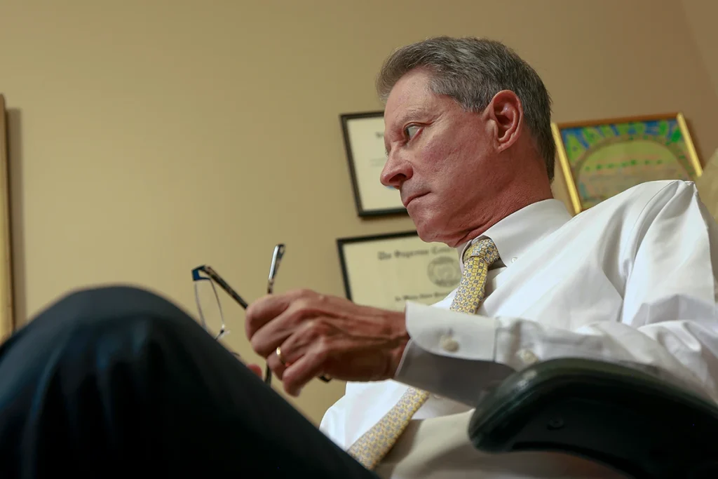 Tom mccutcheon and joel hamner meet with a client to review a traffic accident case.