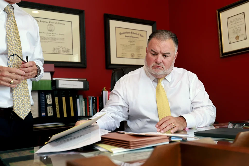 Tom mccutcheon and joel hamner meet with a client to review the details of a truck accident lawsuit.