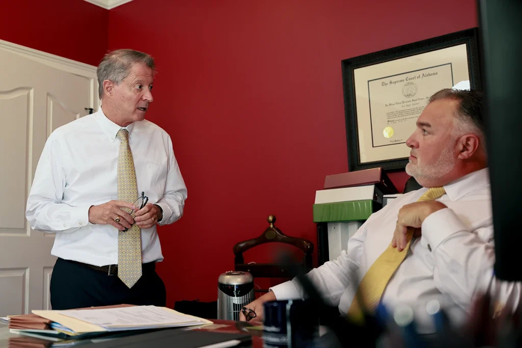 Tom mccutcheon and joel hamner review photographs with a client to evaluate a scars and disfigurement case.