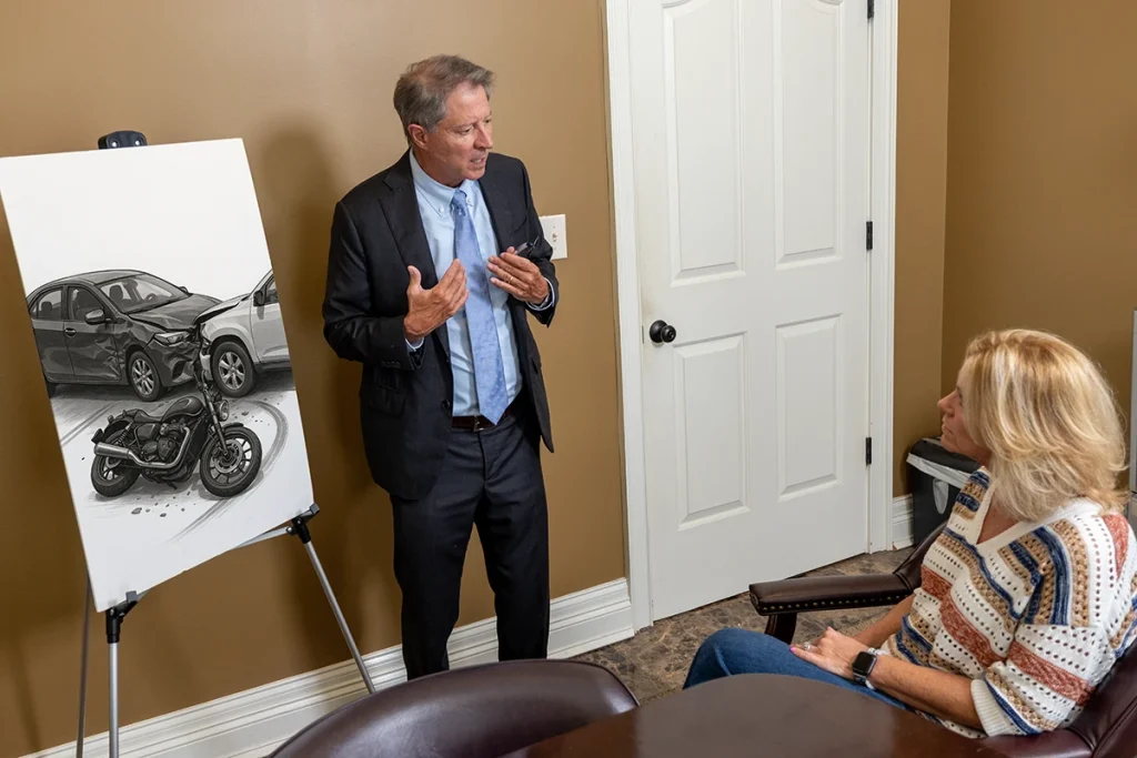 Tom mccutcheon discusses a motorcycle accident claim with a client in the conference room.